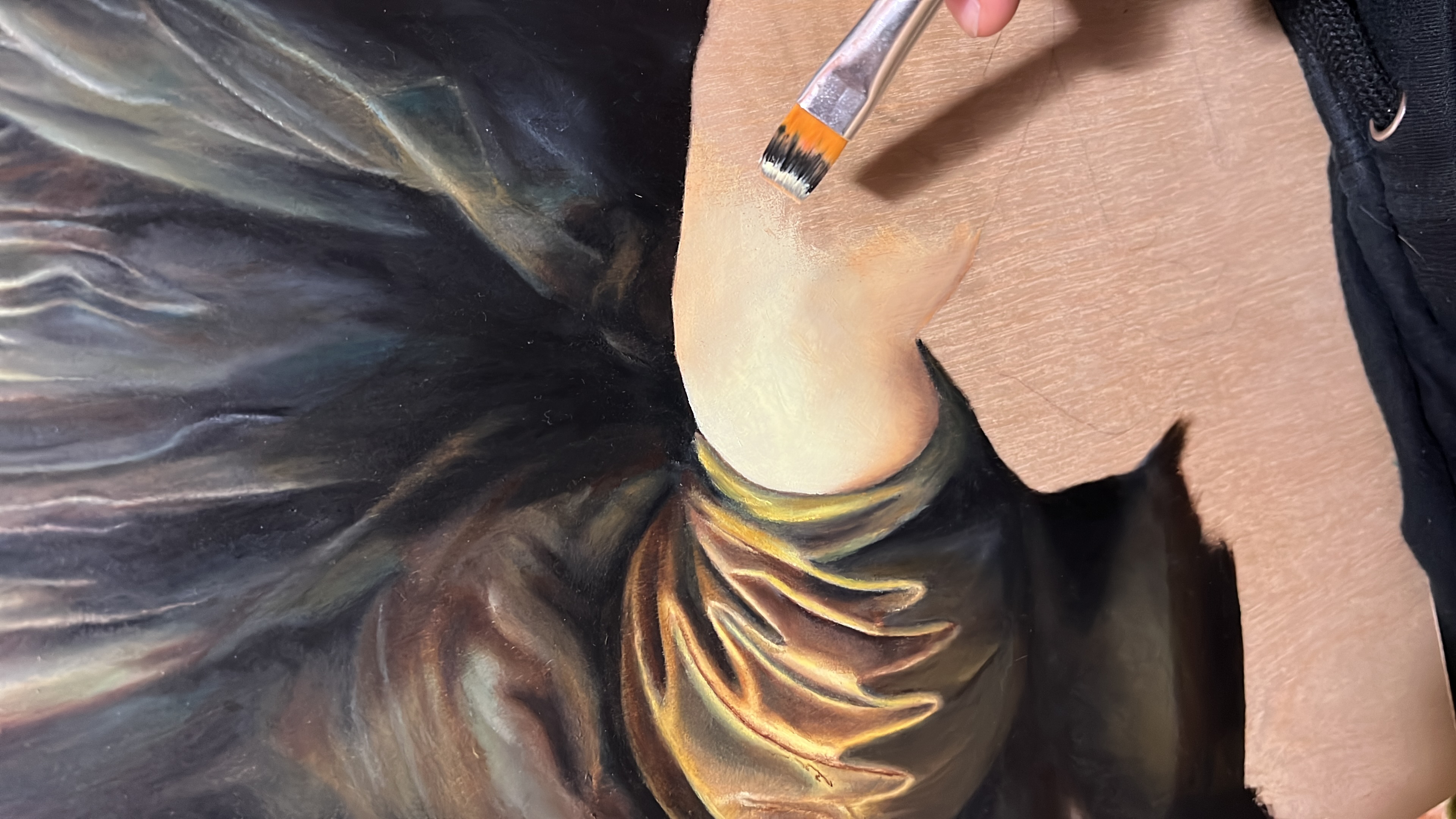 Détail d’un pinceau posant de la peinture sur une œuvre en cours